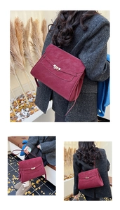 Detail of burgundy suede leather briefcase bag with golden clasp and vintage texture