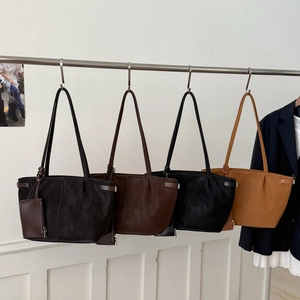 Hanging display of four vintage large capacity faux suede tote bags in earthy colors