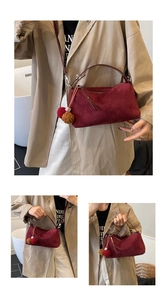 Détail du sac porté épaule bordeaux mat vintage avec un accessoire pompon en fourrure