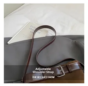 Close-up of adjustable brown leather shoulder strap with silver buckle on bucket bag