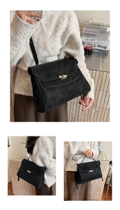Detailed view of the vintage black leather briefcase featuring a gold-tone metal twist lock