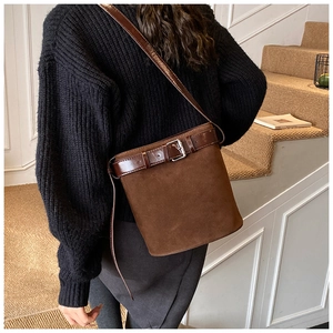 Detail of vintage dark brown bucket bag with smooth leather strap and silver buckle