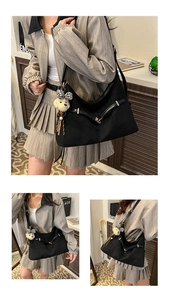 Detail of black tote bag with plush puppy pendant and stylish leopard bow accessory