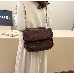 Détail du sac à bandoulière matelassé marron avec bordure en fourrure et chaîne argentée