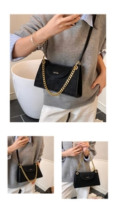 Detail of black suede crossbody bag showing adjustable leather strap and chunky gold chain