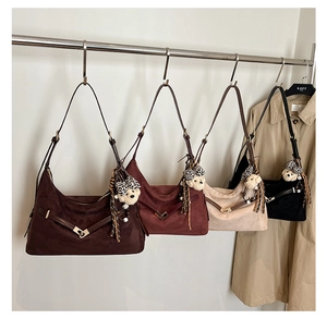 Detailed close-up of suede hobo bags in four colors with cute teddy bear charms