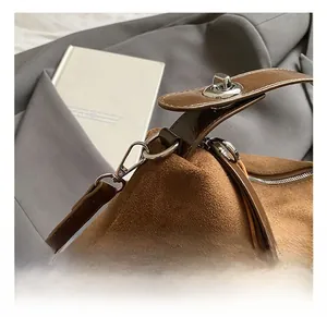 Détail d'un sac à bandoulière en daim marron vintage avec crochet en métal