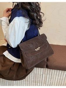 Detail of vintage dark brown faux leather briefcase with a silver metal twist lock closure