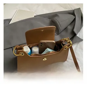 Vue détaillée de l'intérieur du sac en cuir marron montrant le rangement du téléphone