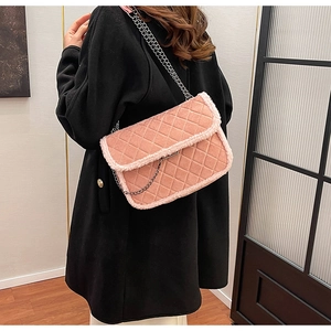 Détail du sac matelassé rose avec garniture en peau de mouton sur un manteau noir