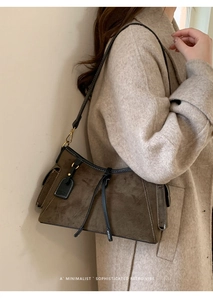 Detailaufnahme der dunkelbraunen Wildleder-Schultertasche mit Goldschnalle
