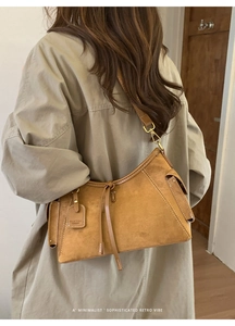 Detail einer braunen Wildleder-Schultertasche mit feinen Nähten und Retro-Seitentasche