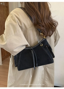 Detailansicht der schwarzen Retro-Wildledertasche mit Ziernähten und Fransen-Applikation