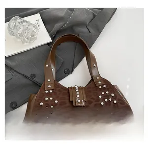 Detail view of leopard print shoulder bag with silver studs on a stylish gray background