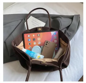 Vue de dessus montrant la grande capacité intérieure d'un sac cabas plissé marron foncé