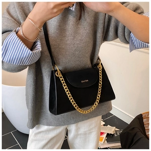 Detail of chic black matte shoulder bag featuring thick gold chain and crossbody strap