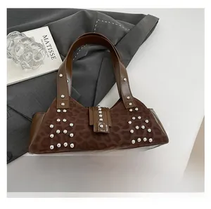 Close-up of leopard print shoulder bag featuring silver rivets and dark brown leather