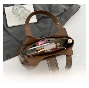 Internal view of the brown leather shoulder bag showing its large capacity and zipper pocket