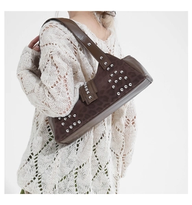 Brown rivet underarm bag with leopard print texture worn by model over white knitwear