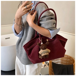 Vue détaillée du sac cabas en daim bordeaux avec un charmant ours en tricot marron