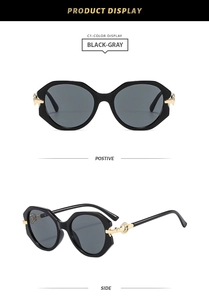 Detail view of round sunglasses featuring signature golden hollow ring hinges and black frames