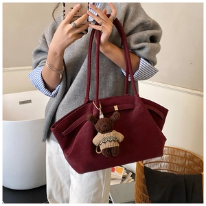 Détail du sac cabas bordeaux en daim avec longues anses et charmant porte-clés ours