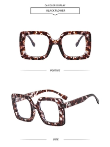 Detail of square oversized glasses in black flower marble finish with metal accents