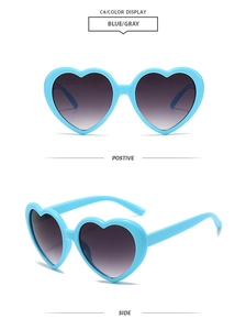Detail view of heart-shaped sunglasses in light blue frame with grey gradient lenses