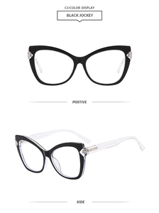Detail view of black cat-eye eyeglass frames with transparent temples and metal hinges