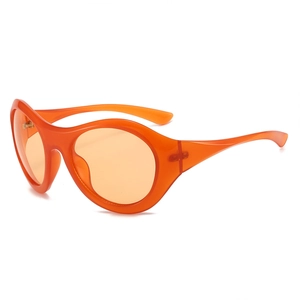 Futuristic orange oversized round frame sunglasses with transparent Y2K style lenses