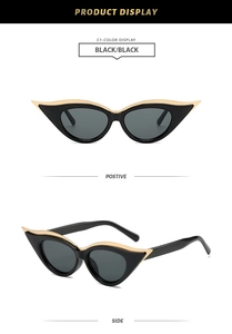 Detail view of cat eye sunglasses featuring black frames with gold metal trim and dark lenses