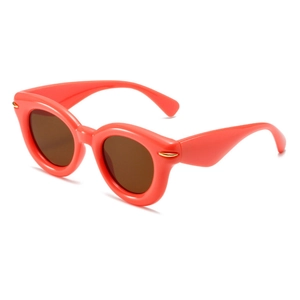 Fashionable oversized oval puff sunglasses in coral orange with thick frames and dark lenses