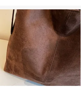 Detailed macro view of deep brown suede tote texture with precise vertical stitching