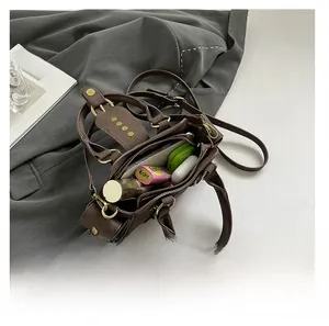 Top view of spacious interior of brown vintage tote bag with daily essentials inside