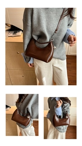 Detail of a dark brown half-moon underarm bag with smooth leather and silver ball charm