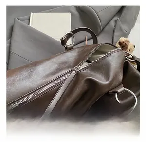 Dettaglio della borsa tote in pelle marrone con fibbie argento e fodera a spina di pesce