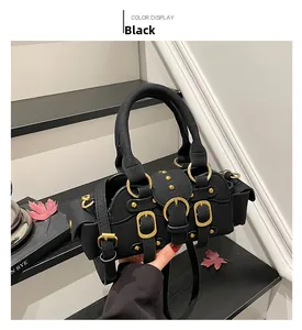Dettagli di una borsa moto vintage nera con fibbie dorate e borchie in mano