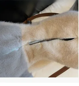 Macro detail of silver metal zipper and soft faux fur texture on the beige tote bag