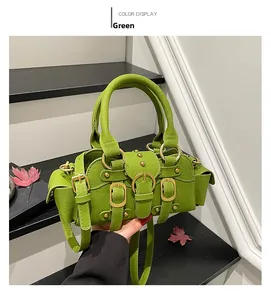 Dettaglio della borsa in pelle scamosciata verde con fibbie dorate e tracolla