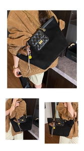 Close-up of black tote bag with quilted front pocket, gold chain and heart tassel details