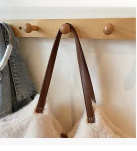 Detailed close-up of a plush faux fur bucket bag featuring a sturdy leather strap