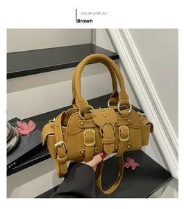 Dettaglio della borsa marrone scamosciata con fibbie vintage e decorazioni con borchie