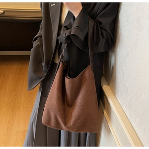 Macro shot of dark brown suede hobo bag texture and elegant minimalist stitching detail