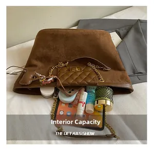 Macro view of brown suede tote bag interior capacity with essentials and chain pouch