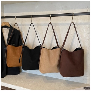 Detailed display of four suede bucket bags in different colors on minimalist wall hangers