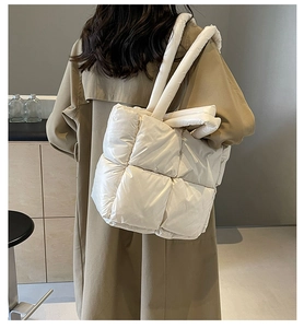 Detail view of cream quilted tote bag showing large square padding and thick strap