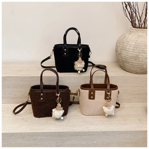 Plush lamb wool bucket bags in black, brown, and beige with leather trim and charms