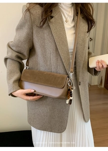 Detailed view of vintage retro brown crossbody bag with wooden bead charm and strap
