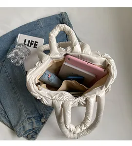 Detailed top view of a white quilted tote bag showing large capacity for tablet and umbrella
