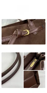 Dettaglio macro della borsa tote in pelle scamosciata marrone con zip e cuciture